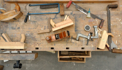 verschiedene Holzwerkzeuge auf einer Werkbank 